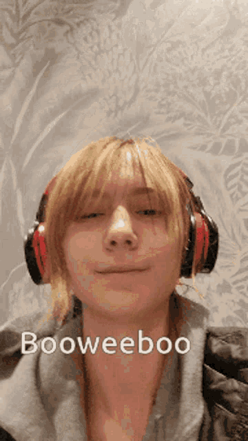a woman wearing headphones says booweeboo on the bottom of her face