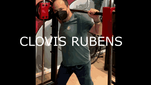 a man wearing a mask is squatting on a machine with the name clovis rubens above him