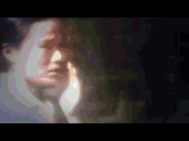 a blurry picture of a woman 's face with her hand to her face