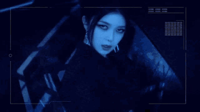 a close up of a woman 's face in a dark room with a blue light behind her .