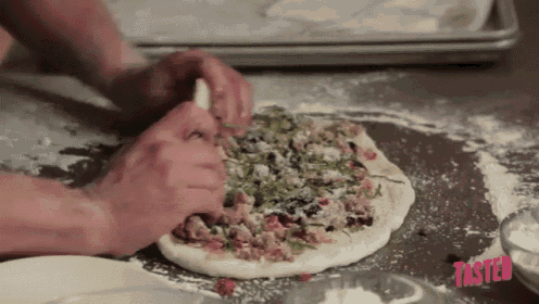 a person is making a pizza and the word tasted is on the table