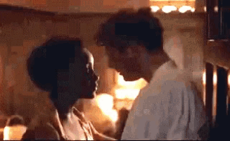 a man and a woman are kissing in a room