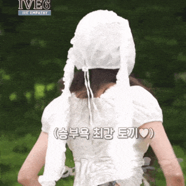 a woman wearing a white top and a white hat with ive6 written on the top