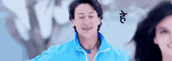 a man in a blue jacket is smiling in front of a woman .