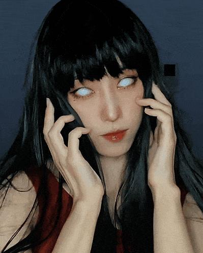 a woman with black hair and white eyes is holding her hands to her face
