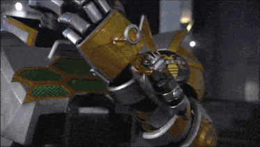 a close up of a robot 's arm with a green and gold shield on it