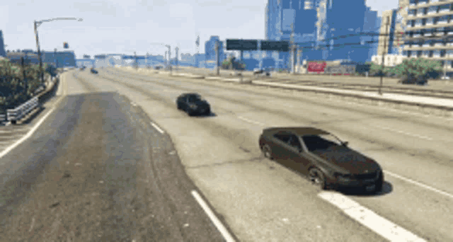 a few cars are driving down a highway with a city in the background