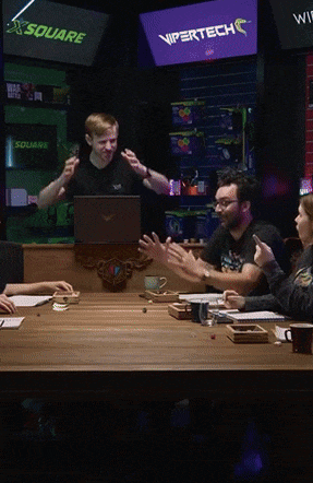 a group of people are sitting around a table with a vipertech sign behind them