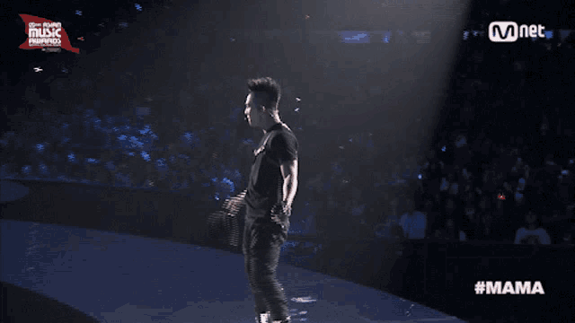 a man singing into a microphone on a screen that says mama