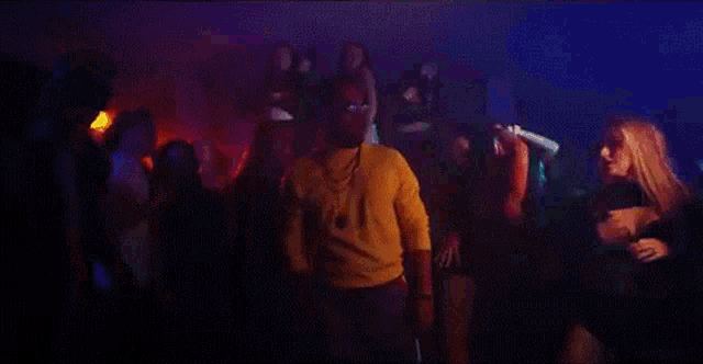 a man is dancing in front of a crowd of people at a party in a club .