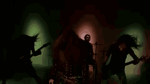 a group of people playing instruments in a dark room .