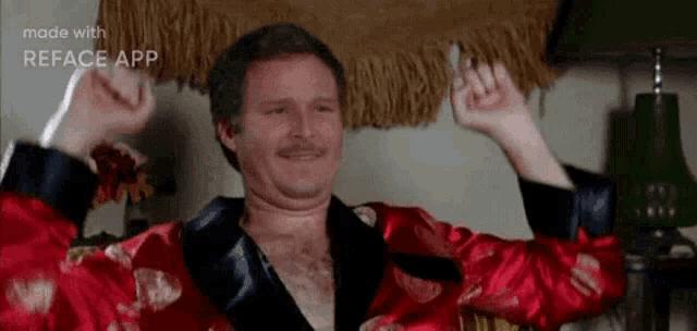 a man in a red robe is sitting in a chair with his arms outstretched .