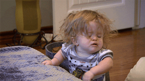 a little girl wearing a reebok shirt is making a funny face