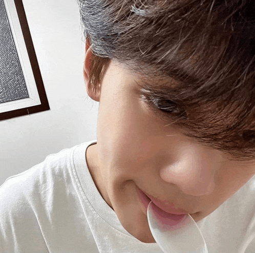 a close up of a person 's face with a white shirt on