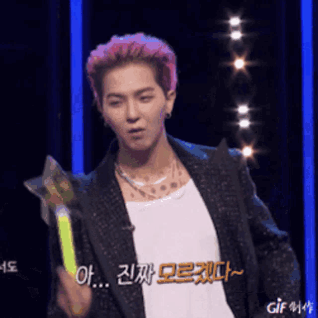 a young man with pink hair is holding a star shaped object