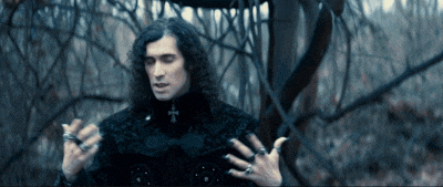 a man with curly hair and a cross on his chest