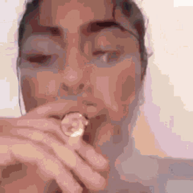 a woman is smoking a pipe with her eyes closed and her mouth open .