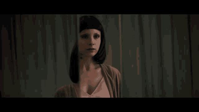 a woman is standing in front of a green curtain with her head visible