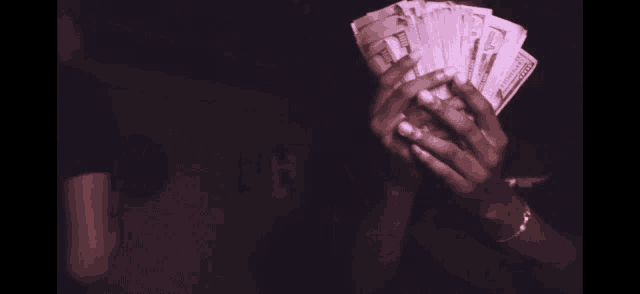 a person is holding a fan of one dollar bills