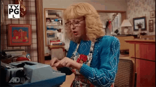 a woman is typing on a typewriter with a tv pg logo in the background