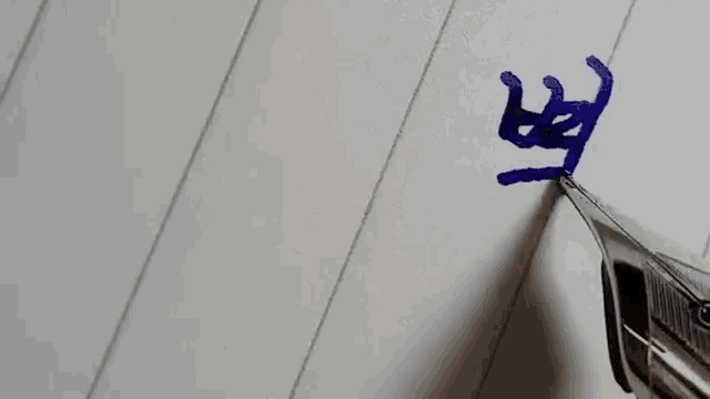 a close up of a fountain pen writing on a piece of paper with blue ink .