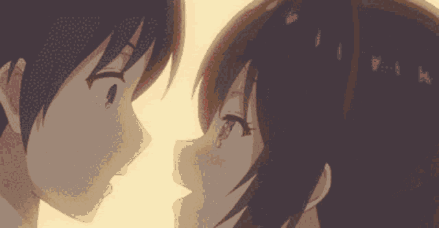 a boy and a girl are looking at each other in a close up of their faces .
