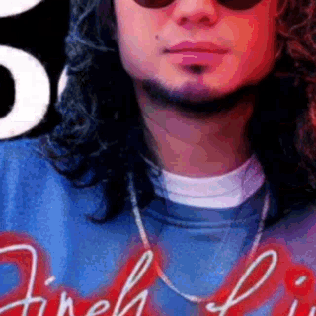 a close up of a man wearing sunglasses and a blue shirt with the word fireball on it