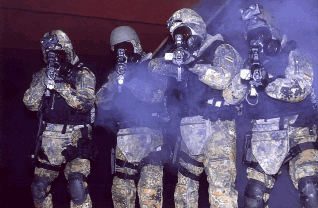 a group of soldiers wearing gas masks are standing in a line holding guns