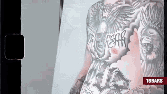 a man with a lot of tattoos on his chest is shown on a screen that says 16 bars
