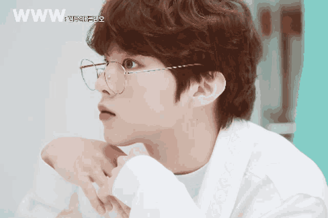 a close up of a person wearing glasses with the word www on the bottom right