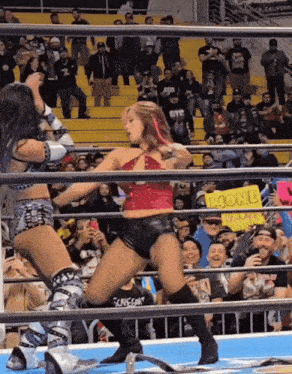 two women in a wrestling ring with a sign that says mom