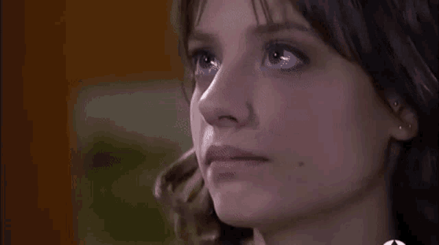 a close up of a woman 's face with tears coming down her face .
