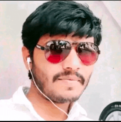 a man with a beard is wearing sunglasses and earphones .