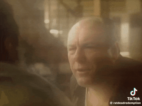 a close up of a bald man 's face with a blurred background