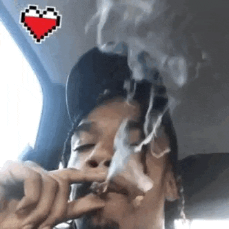 a man is smoking a cigarette in a car with a heart sticker on it .