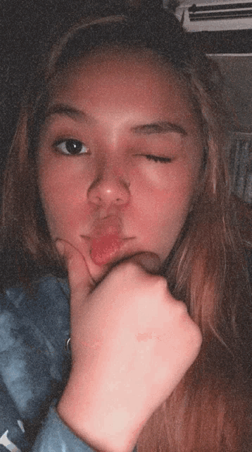 a girl with her eyes closed and her tongue out