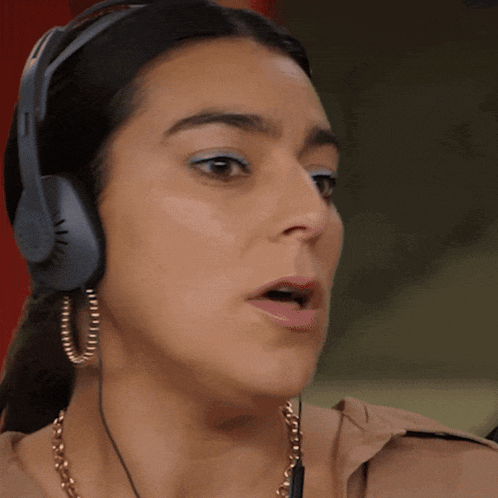 a close up of a woman wearing headphones and a necklace