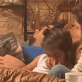 a group of people are sitting on a couch with a man sleeping on the couch .