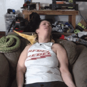 a woman laying on a couch wearing a rebel tank top