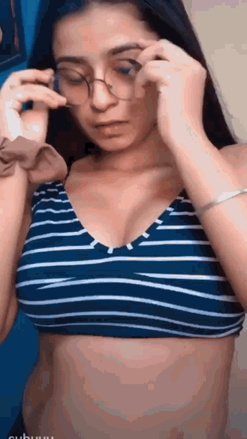 a woman wearing glasses and a striped top