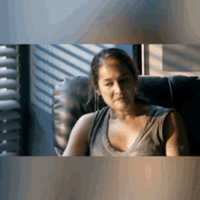 a woman is sitting in a chair in front of a window .