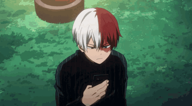 a man with red and white hair is looking at his phone