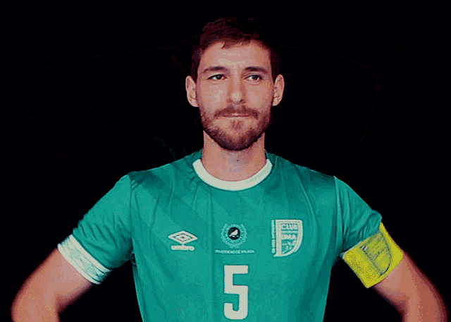 a man is wearing a green jersey with the number 5 on it