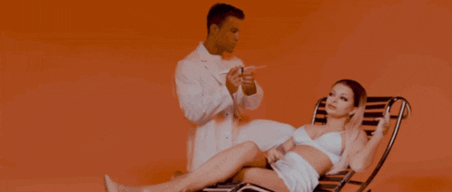 a man in a lab coat is giving a woman a shot
