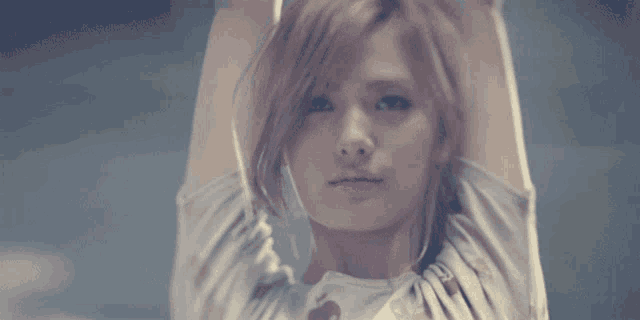 a close up of a woman 's face with her hands on her head