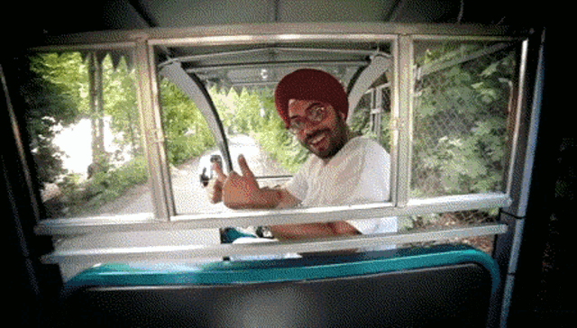a man wearing a red turban is giving a thumbs up