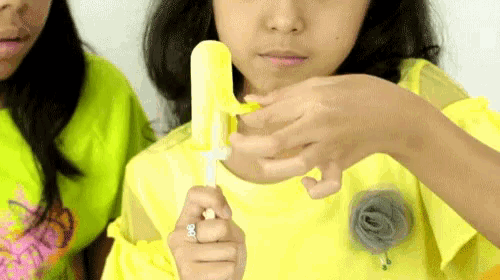 a girl with a ring on her finger holds a popsicle