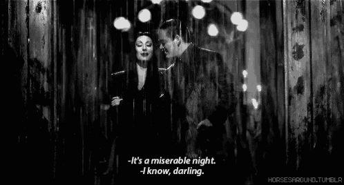 a black and white photo of a man and a woman in the rain .