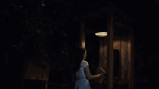 a woman in a white dress is talking on a phone