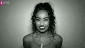 a black and white photo of a woman smiling and winking at the camera .